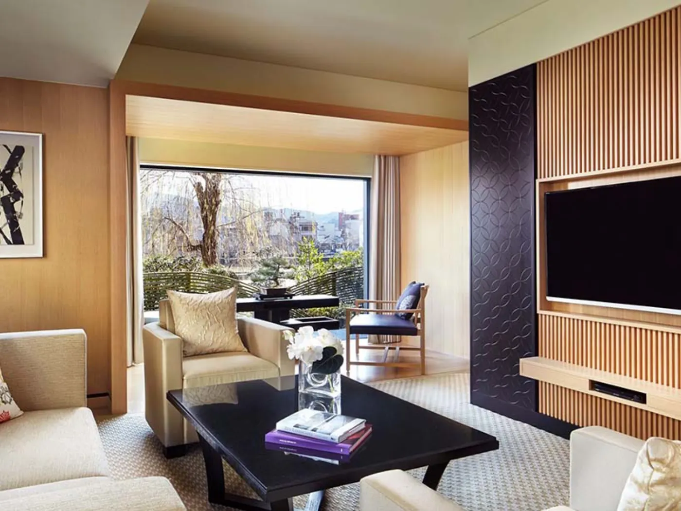 Suite du Ritz-Carlton Kyoto : boiseries claires, table basse noire et baie ouverte sur le jardin