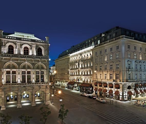 Hôtel Sacher à Vienne, sa façade aux stores rouges illuminée la nuit, face à l'Opéra