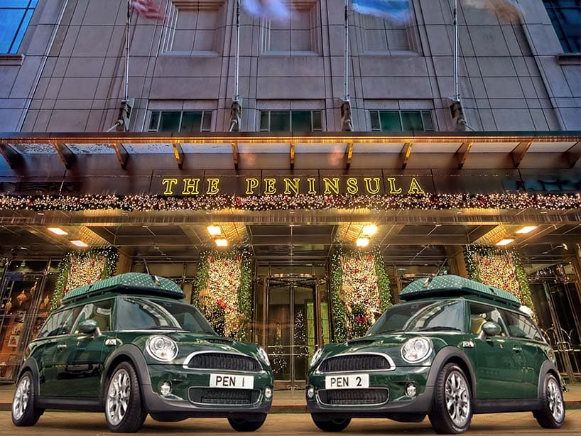 Entrée du Peninsula décorée pour Noël, avec les deux Mini Cooper vertes immatriculées PEN 1 et PEN 2