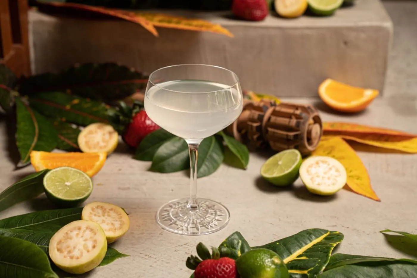 Cocktail signature du Zapote Bar entouré de citrons verts, goyaves et tranches d'orange