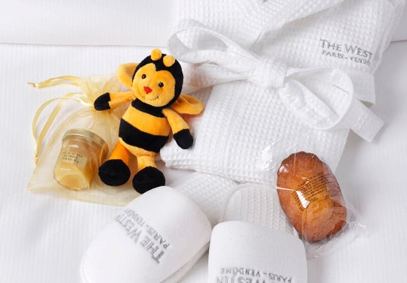 Cadeau de bienvenue du Westin Paris-Vendôme : peluche abeille, pot de miel, peignoir et chaussons brodés