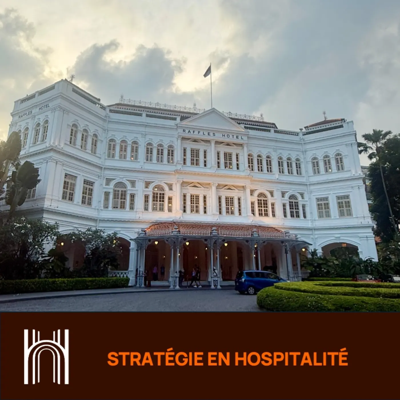 Façade blanche du Raffles Hotel de Singapour au crépuscule, bandeau Delporte Hospitality « Stratégie en hospitalité »