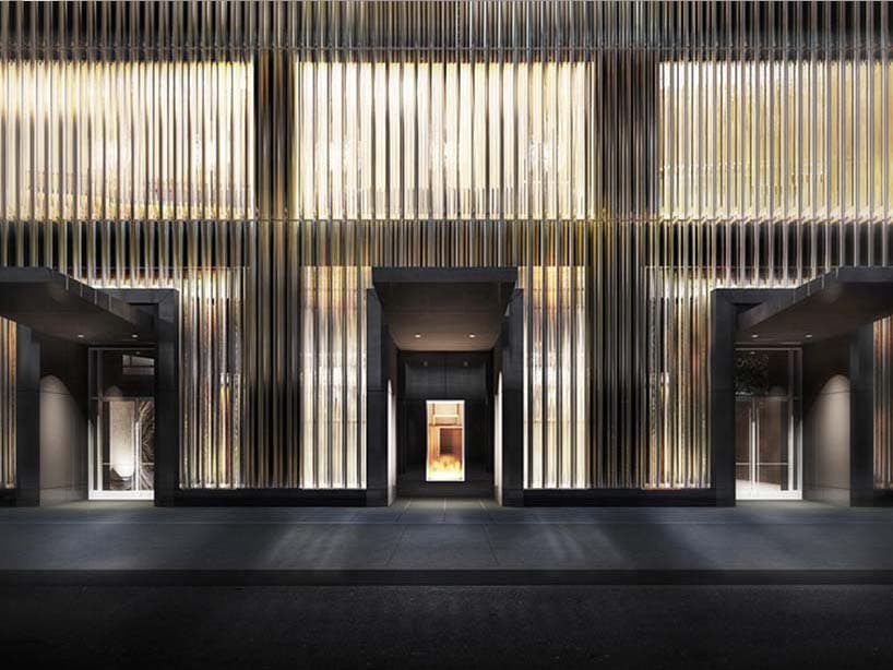 Façade du Baccarat Hotel illuminée la nuit, ses lames de verre verticales et ses trois porches sombres