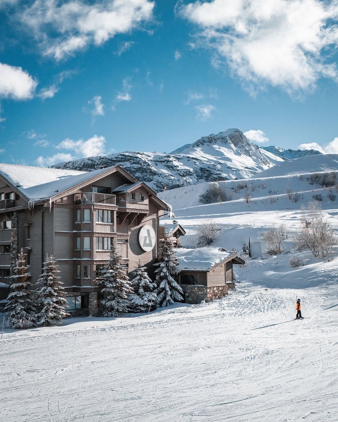 Chalet de montagne chaleureux sous la neige illustrant l'hospitalité d'altitude