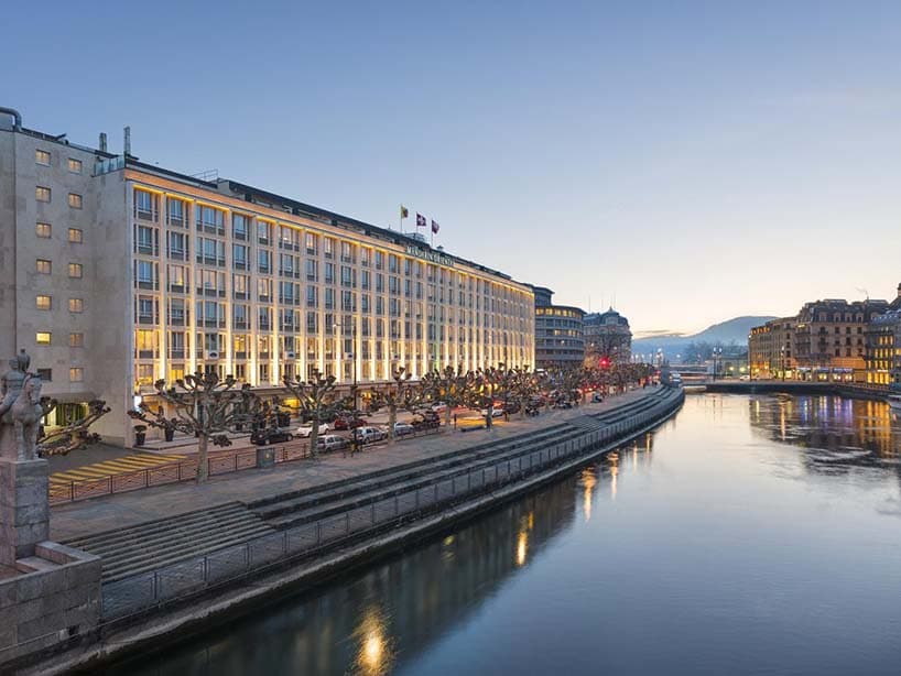 Façade éclairée d'un hôtel Mandarin Oriental le long du fleuve, à la tombée du jour