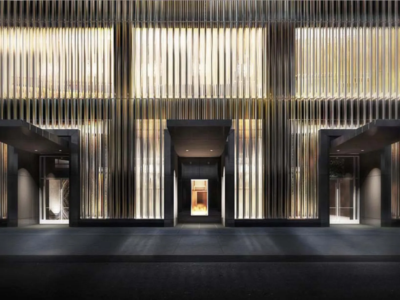 Façade d'hôtel de nuit, habillée de lames verticales dorées et lumineuses au-dessus de trois entrées sombres