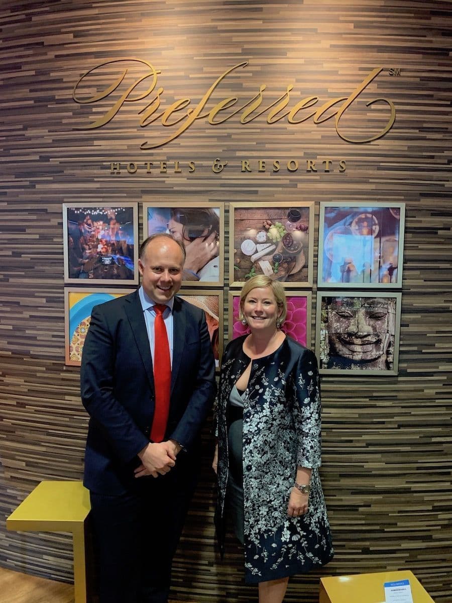 Laurent Delporte et Lindsey Ueberroth devant l'enseigne dorée Preferred Hotels & Resorts