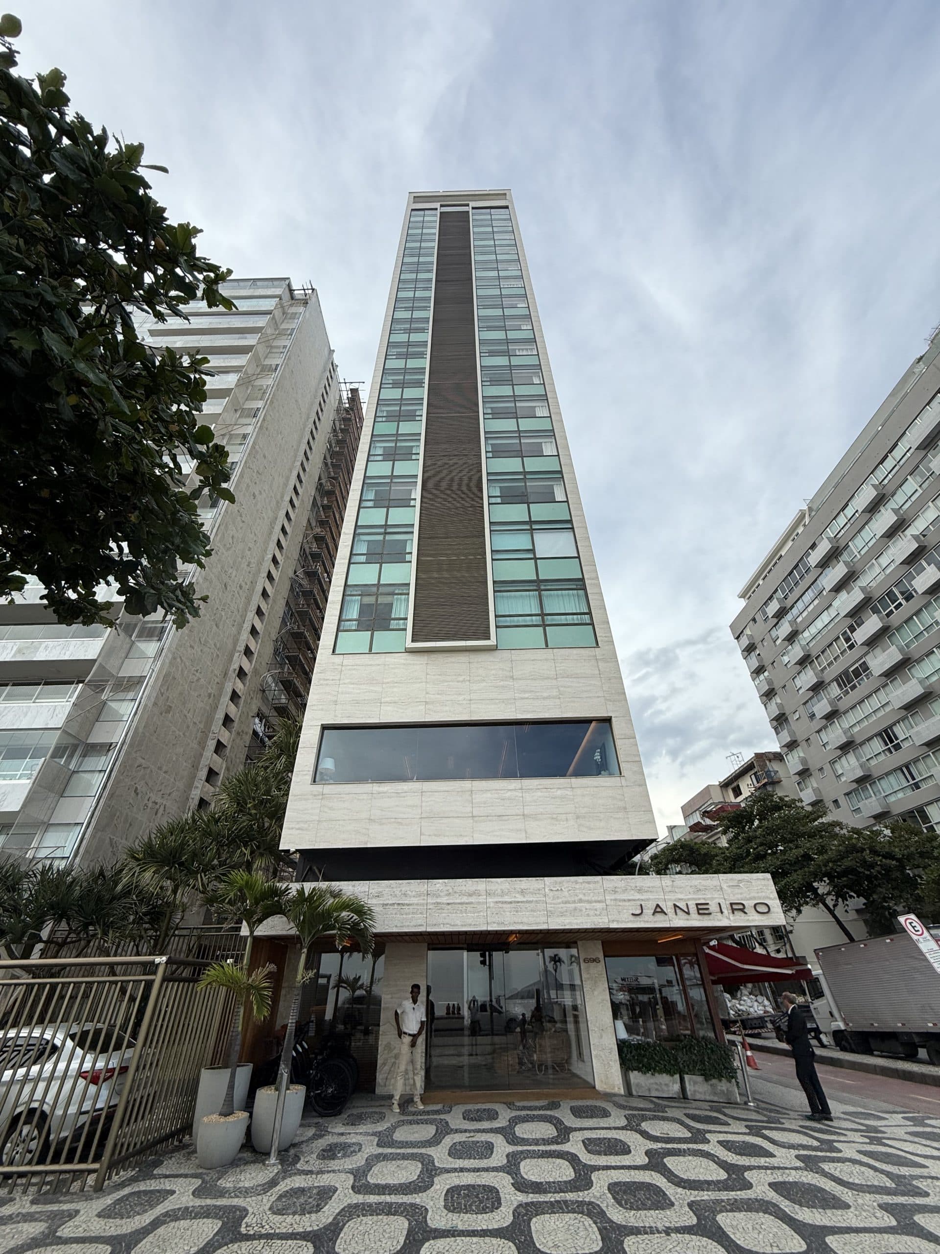 Façade étroite du JANEIRO Hotel à Leblon, son enseigne et le trottoir en mosaïque noir et blanc de Rio