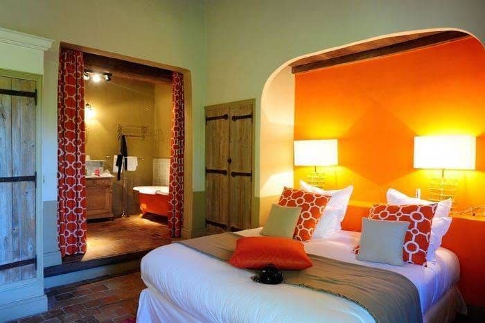 Chambre du Hameau des Baux : alcôve orange, portes de bois ancien et salle de bains ouverte