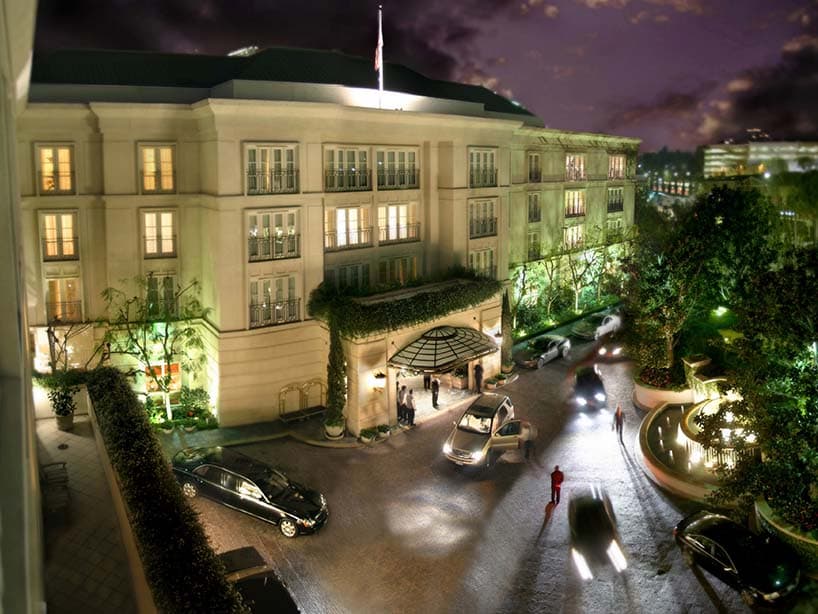 Le Peninsula Beverly Hills illuminé la nuit, sa marquise de verre et son allée d'arrivée
