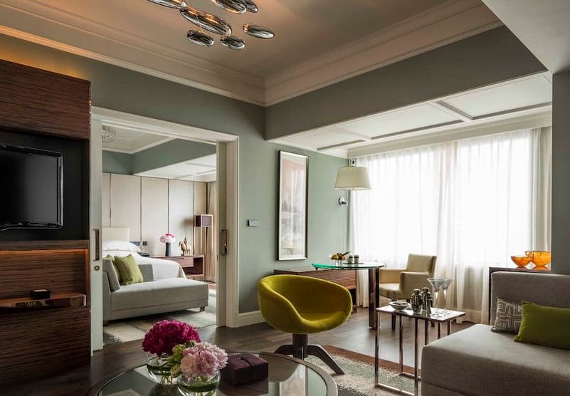 Suite du Four Seasons : salon vert amande, fauteuil jaune et chambre en enfilade derrière