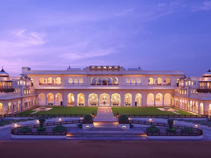 Palais indien Taj illuminé au crépuscule, ses arcades et ses pelouses sous un ciel violet