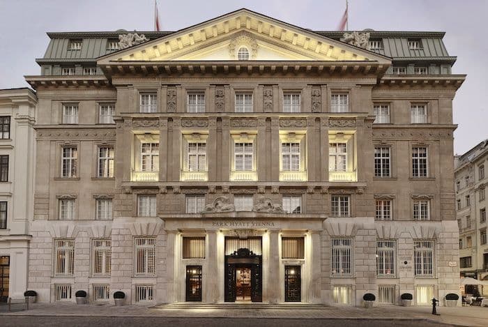Façade néoclassique du Park Hyatt Vienna illuminée, son fronton et son porche de pierre