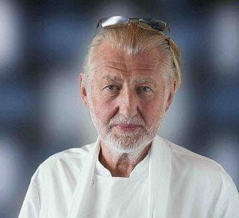 Portrait du chef Pierre Gagnaire en veste blanche, lunettes relevées sur le front