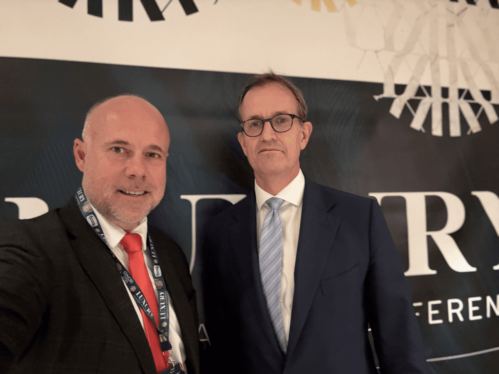Laurent Delporte et un dirigeant hôtelier devant le kakémono de la Luxury Hospitality Conference