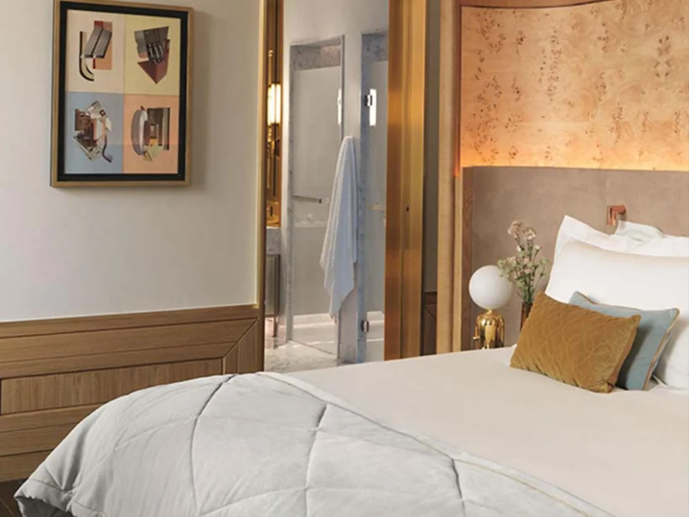 Chambre d'hôtel contemporaine, tête de lit en loupe de bois, coussins moutarde et bleu, salle de bains vitrée