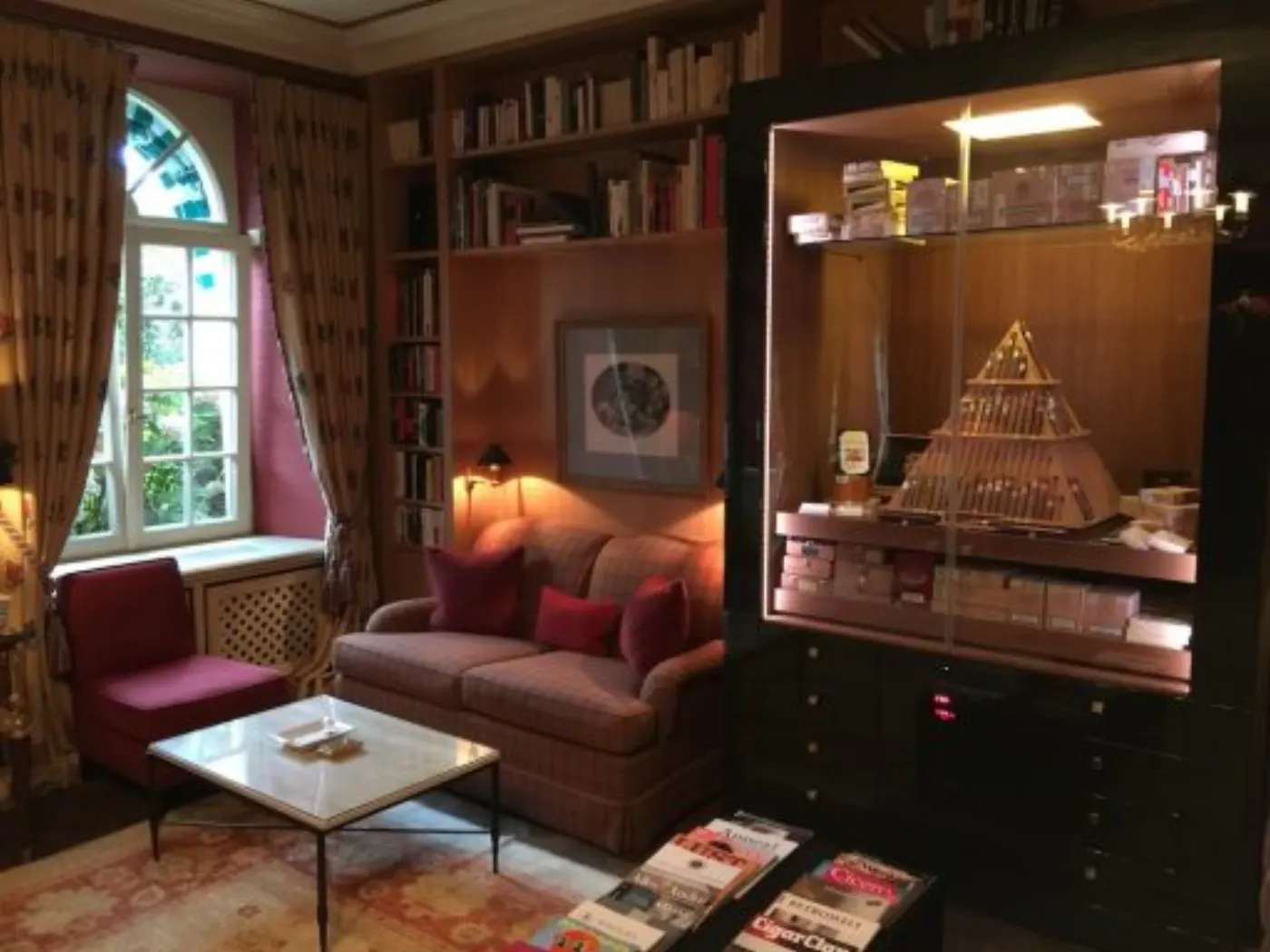 Fumoir du Brenners : bibliothèque, canapé de tweed et cave à cigares vitrée