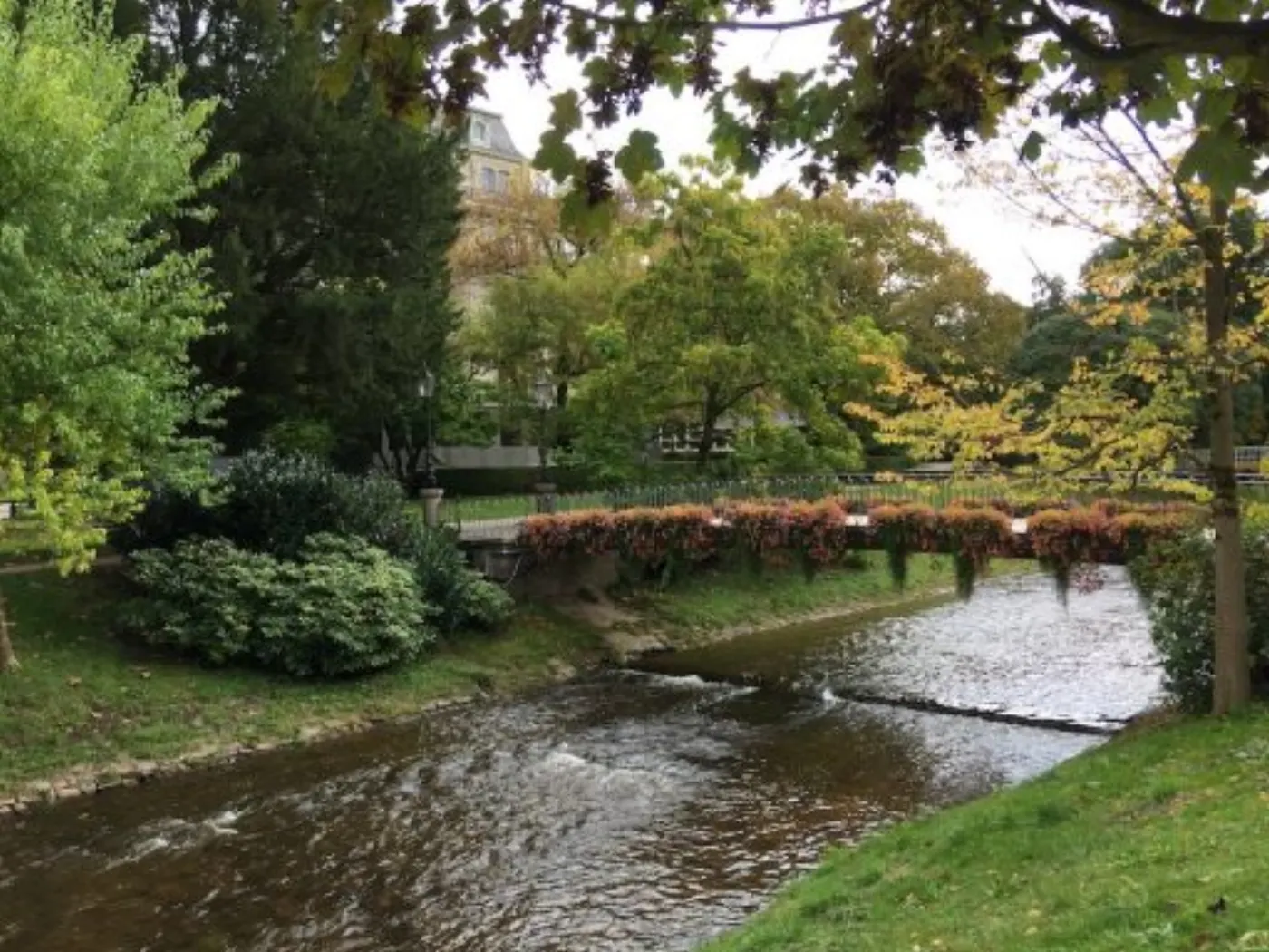 L'Oos traversant le parc de Baden-Baden, sa passerelle fleurie et les arbres d'automne