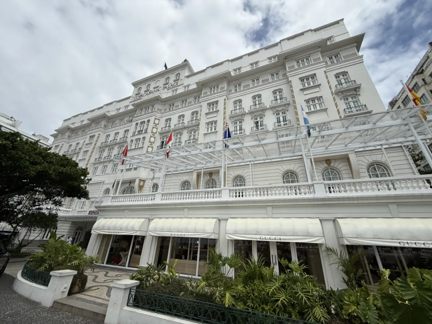 Façade blanche du Copacabana Palace à Rio vue en contre-plongée, boutiques Gucci sous les stores du rez-de-chaussée