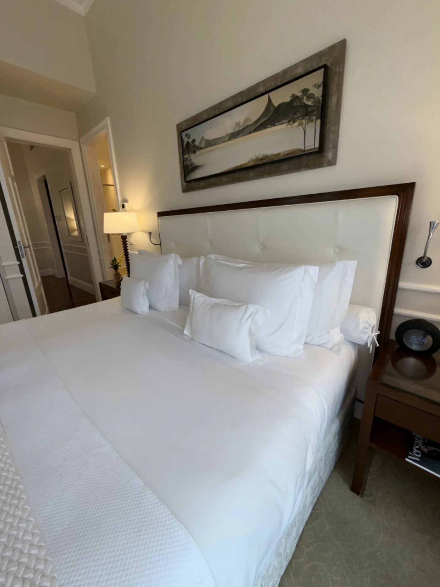 Chambre d'hôtel au lit blanc impeccable, tableau d'un paysage de Rio accroché au-dessus de la tête de lit