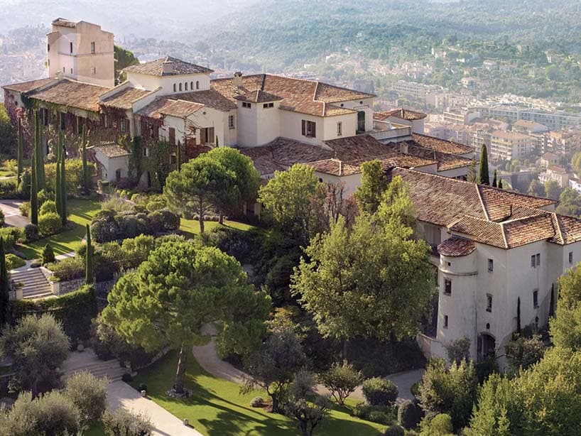 Hôtel provençal perché dans les collines : toits de tuiles, cyprès et jardins dominant le village
