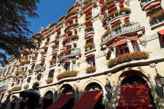 The Plaza Athénée facade on avenue Montaigne, its red awnings and geranium-filled balconies