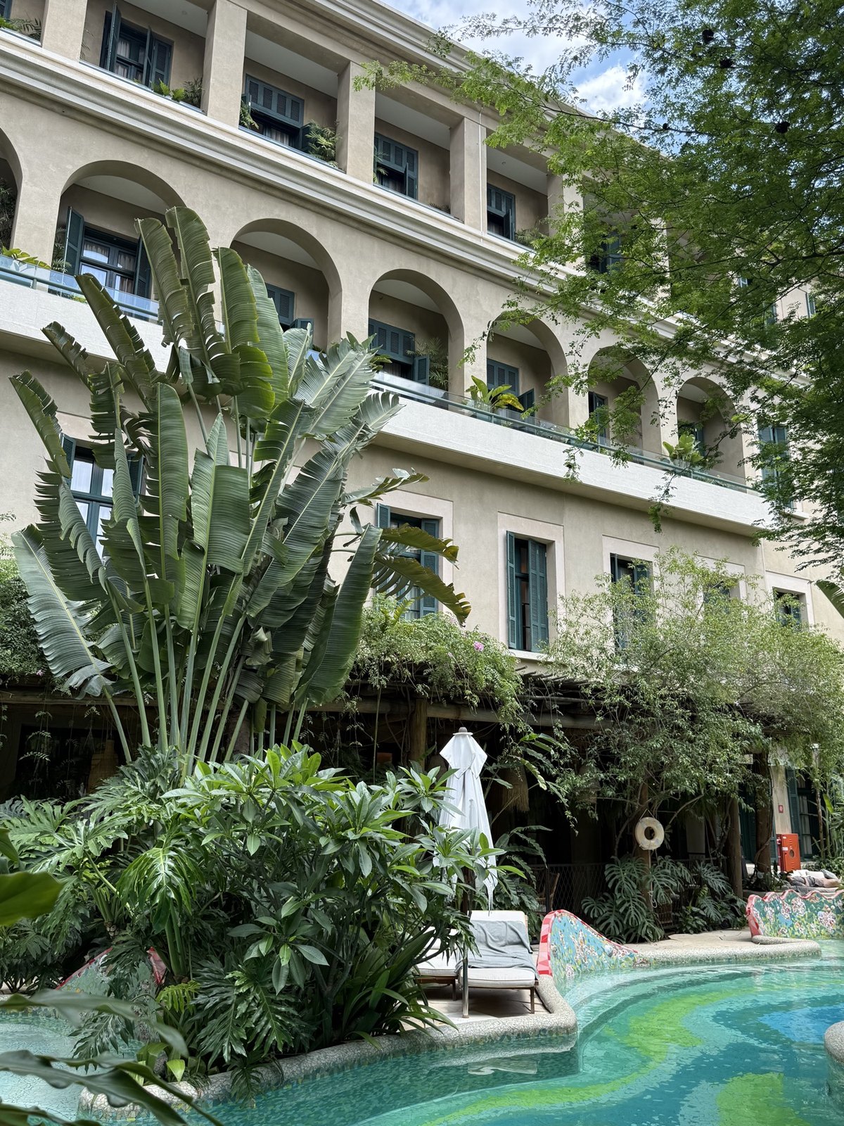 Arched facade and tropical gardens at Rosewood São Paulo