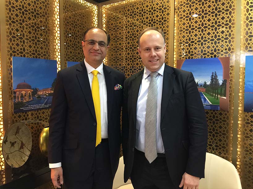 Rencontre sur le stand Oberoi Hotels : deux dirigeants devant les panneaux dorés et les visuels des palaces indiens