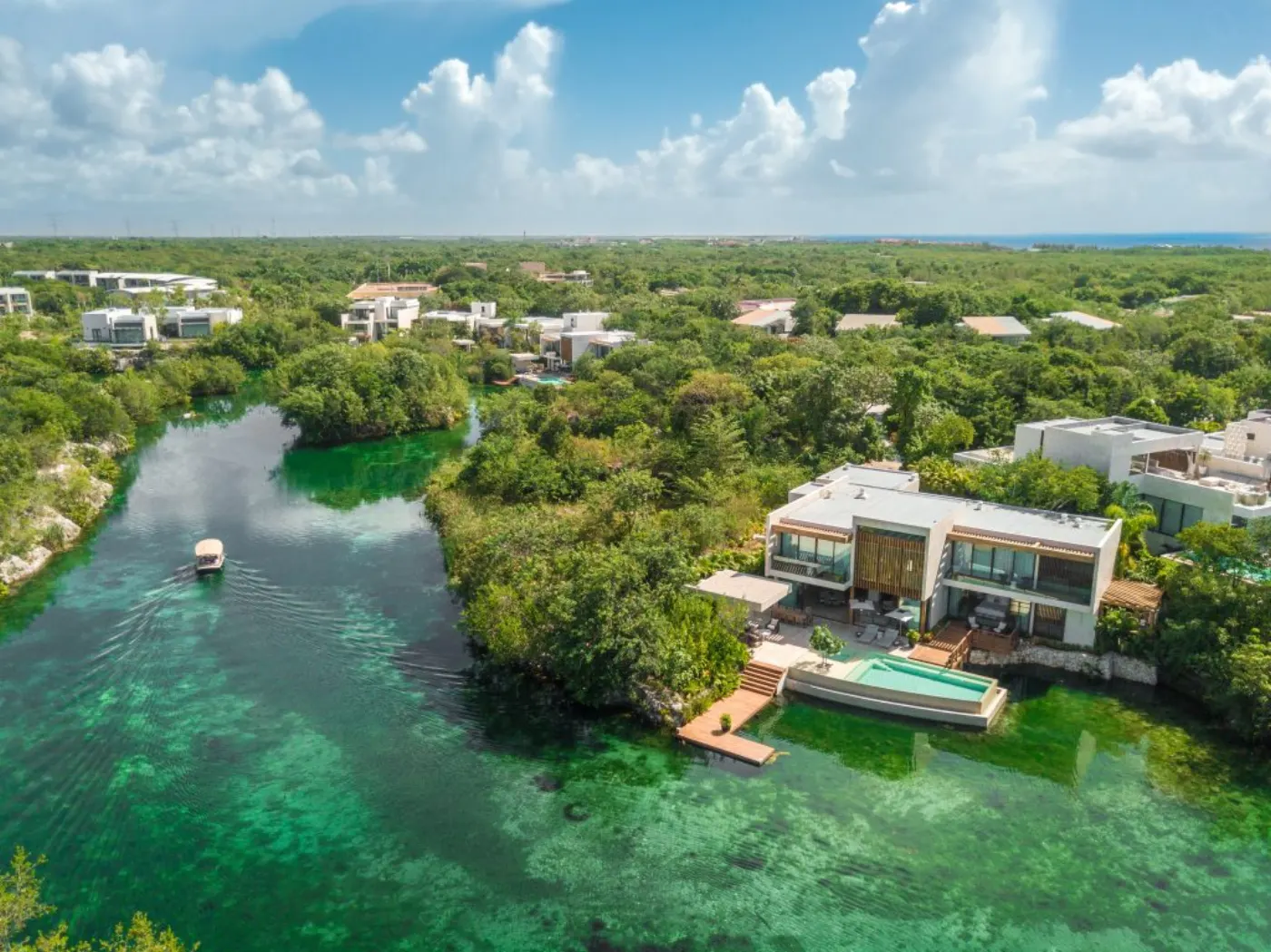 Vue aérienne du Rosewood Mayakoba : villas bordant le lagon émeraude et bateau-navette