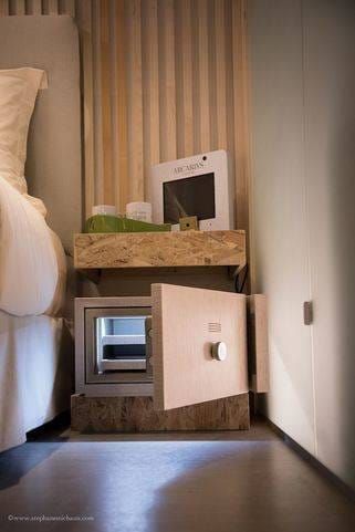 Détail de la Chambre ORIGINE® : coffre-fort et rangement intégrés dans un meuble en bois naturel