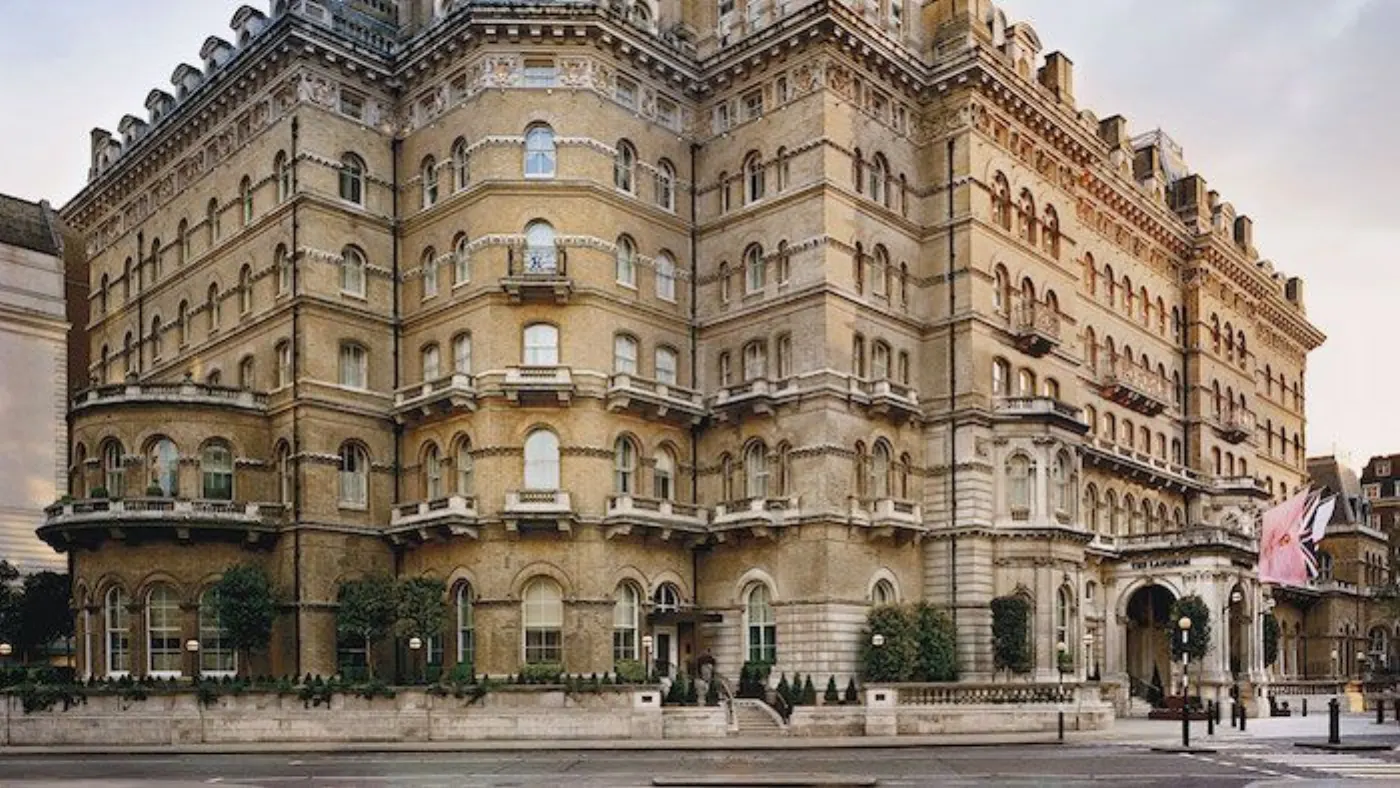 Façade victorienne en pierre claire de l'hôtel The Langham à Londres, auvent d'entrée et drapeau au coin de la rue