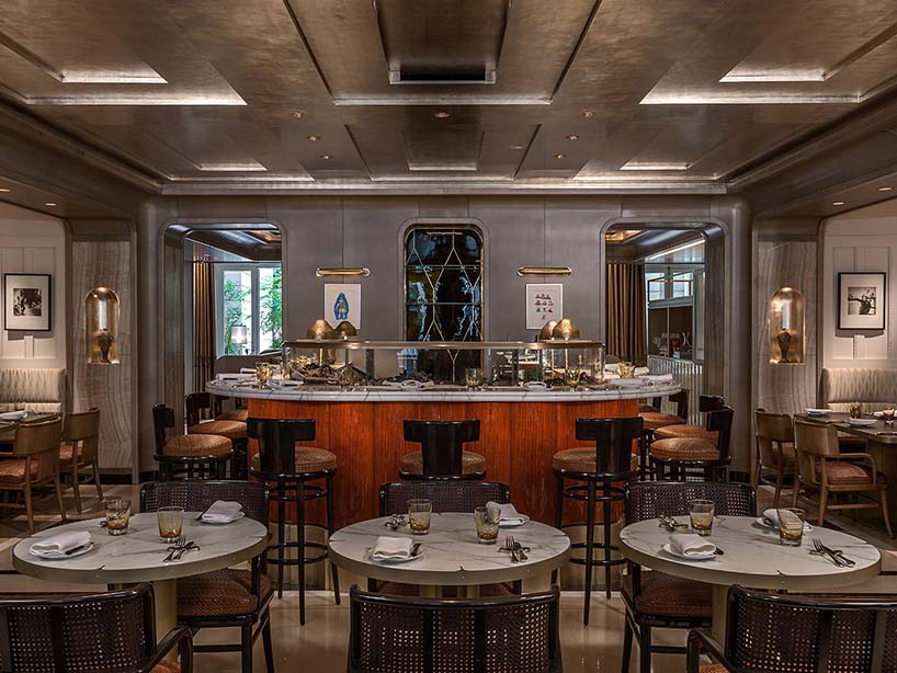 Restaurant de l'Hôtel de Crillon : comptoir central en bois, tables de marbre et plafond métallisé