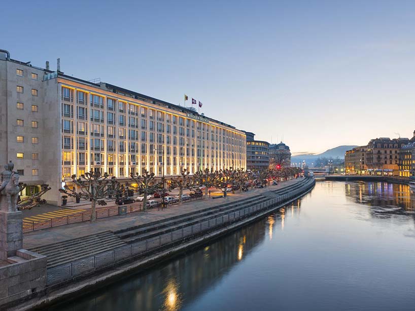 Illuminated Mandarin Oriental hotel facade along the river at nightfall