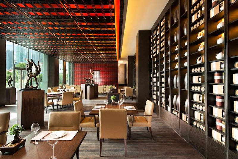 Restaurant du Banyan Tree Shanghai : plafond de résille rouge et mur d'étagères garni de céramiques