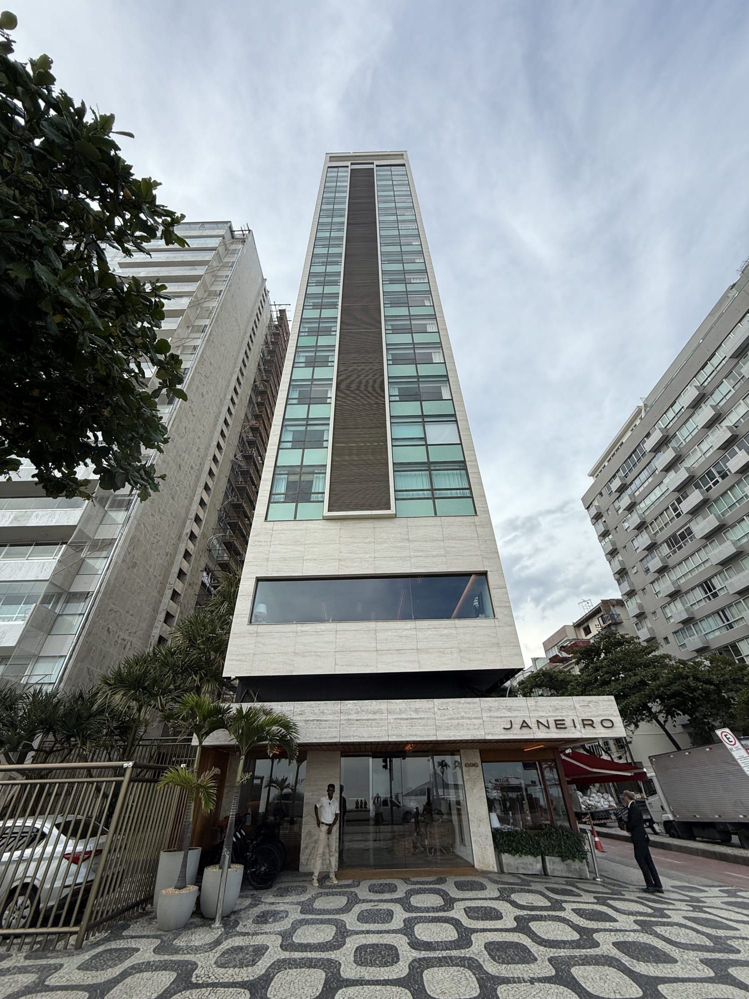 Façade étroite du JANEIRO Hotel à Leblon, son enseigne et le trottoir en mosaïque noir et blanc de Rio