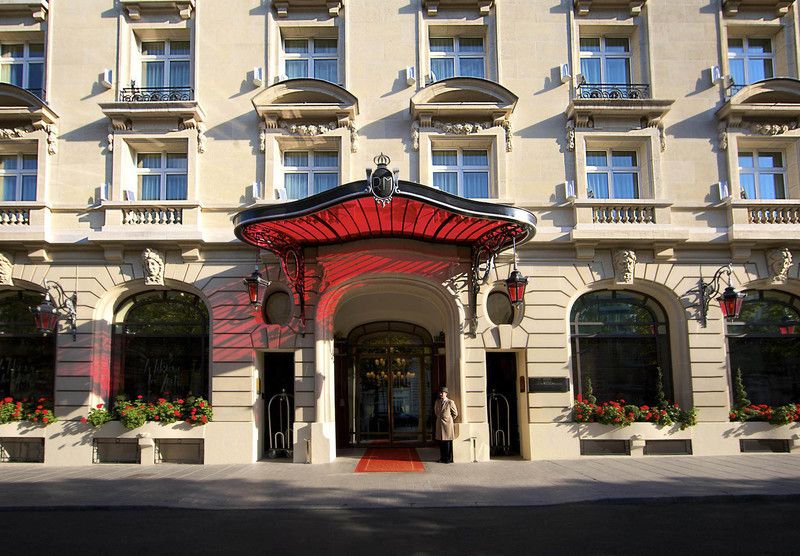 Entrée du Peninsula Paris : la marquise rouge, les lanternes et les jardinières de géraniums